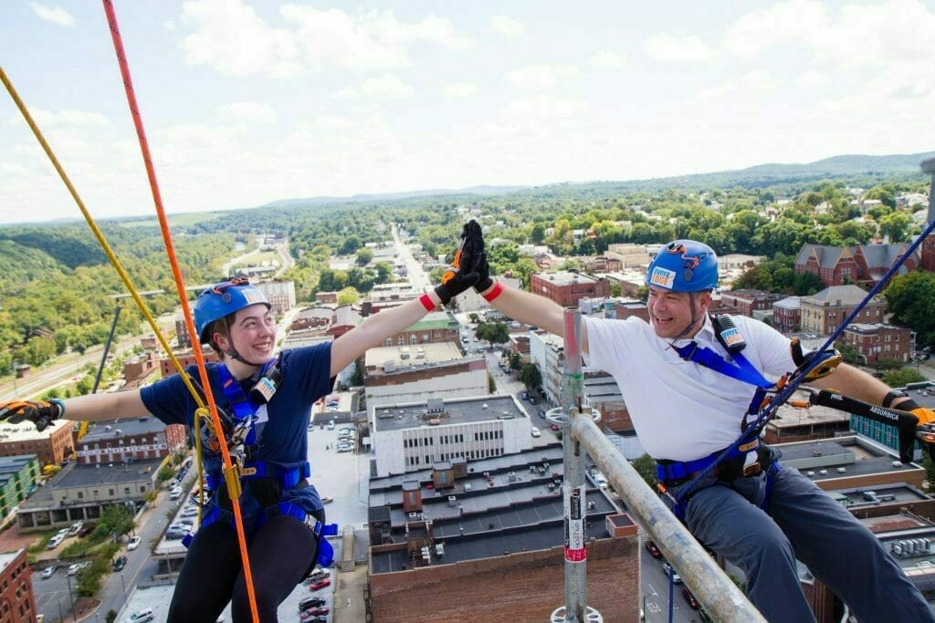 Two over the edge climbers high five