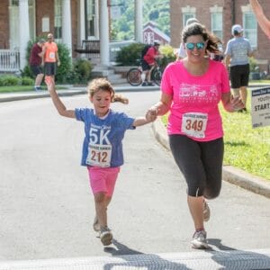 A mother and daughter run across the finish line together