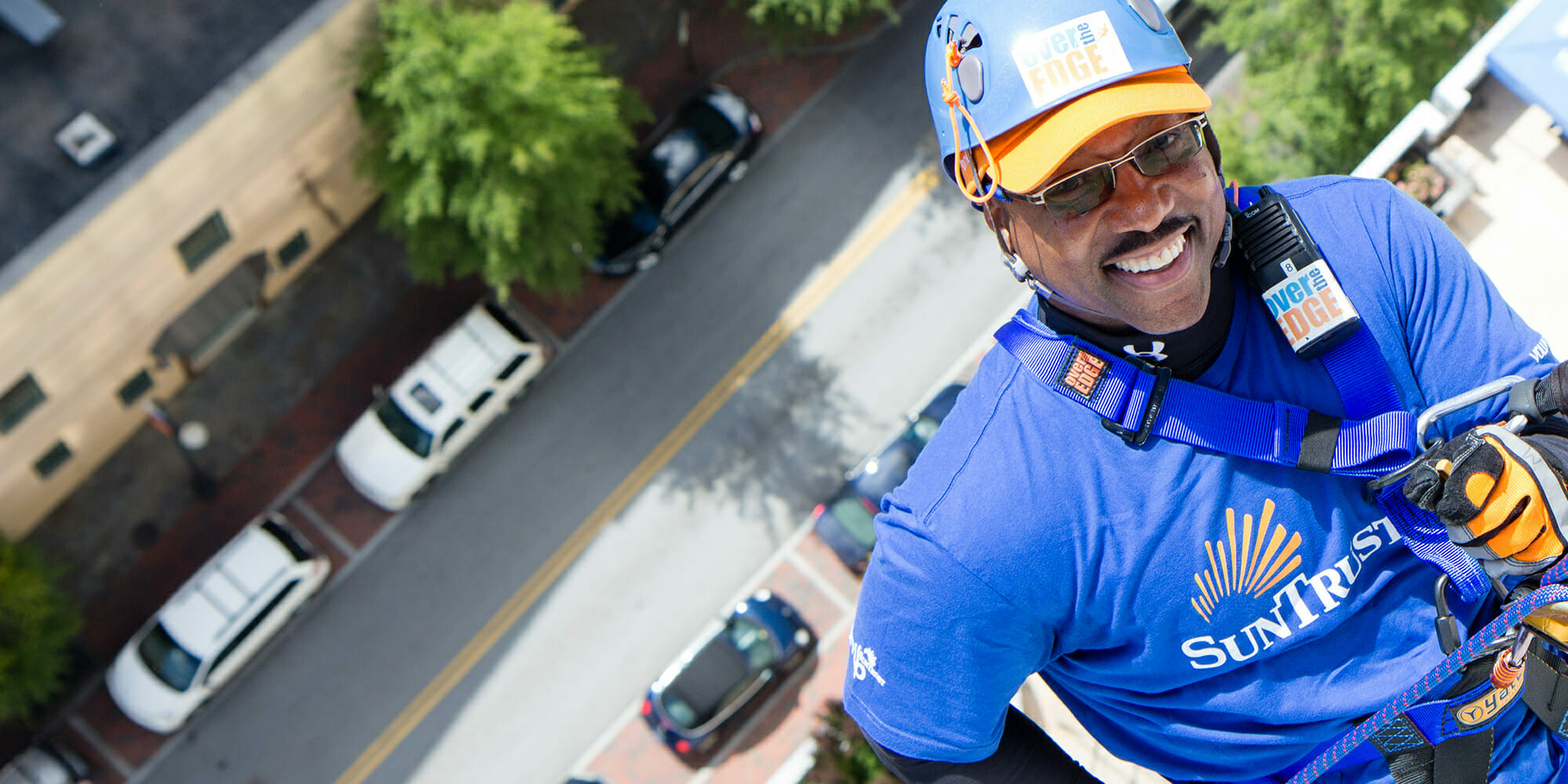 Man belaying off a building for Over the Edge charity event